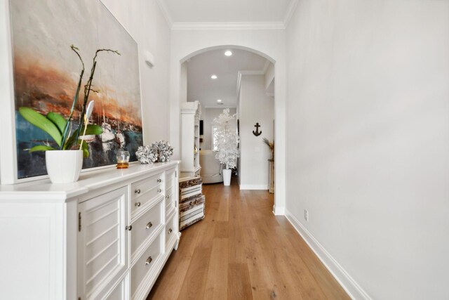 hall with light hardwood / wood-style floors and ornamental molding