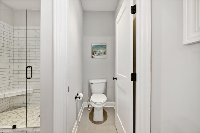 full bathroom featuring tile patterned flooring, a shower stall, toilet, and baseboards