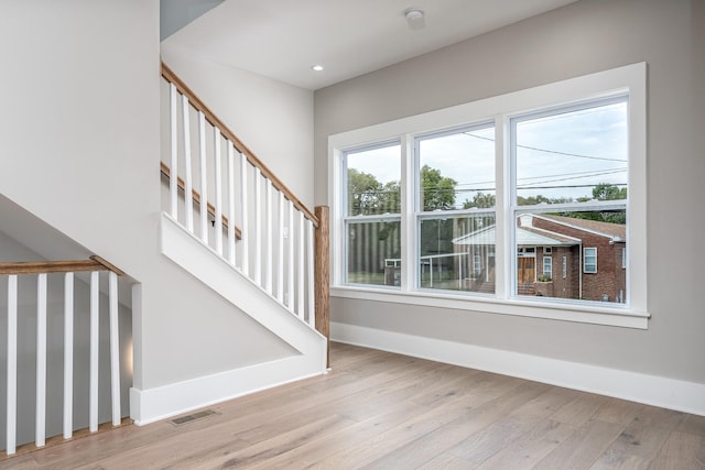 stairway with recessed lighting, visible vents, baseboards, and wood finished floors