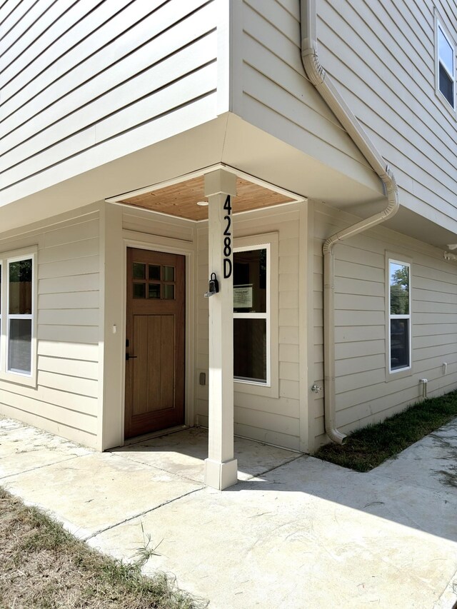 view of exterior entry with a patio area