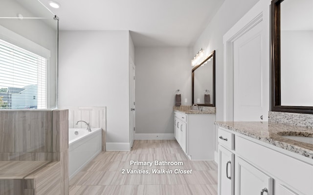 bathroom with vanity, tile patterned floors, and a washtub