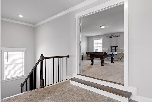 hallway with carpet and crown molding