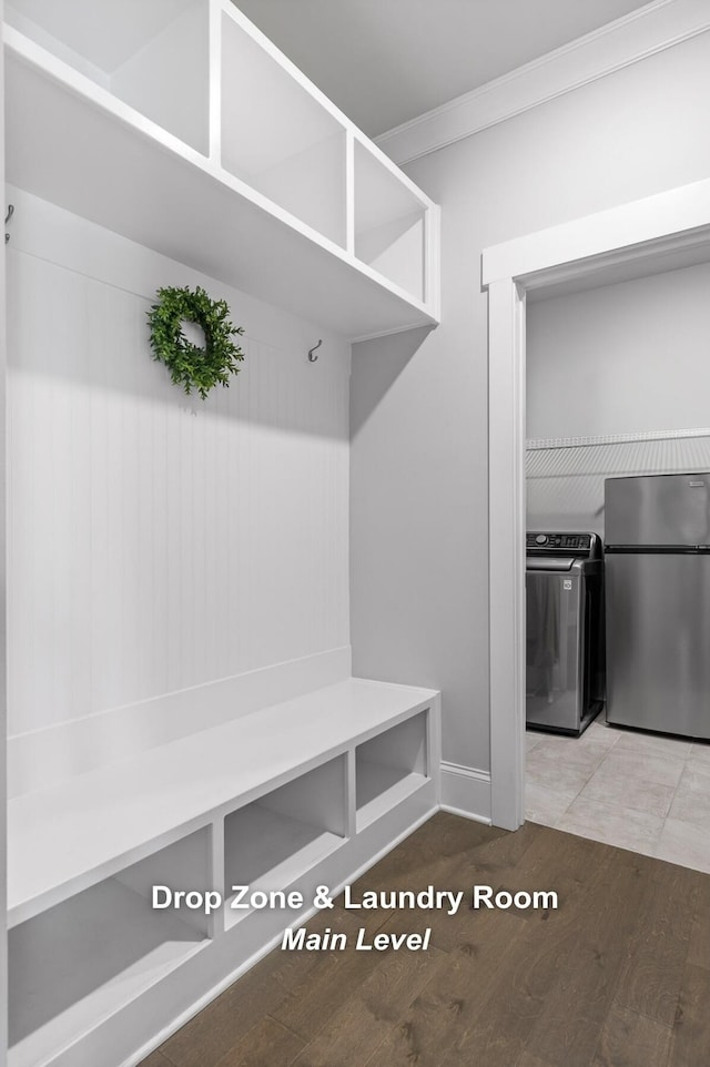 mudroom with crown molding, hardwood / wood-style flooring, and washing machine and dryer