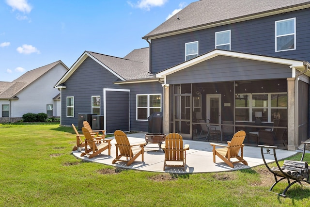 back of property with a lawn, a patio, cooling unit, a fire pit, and a sunroom