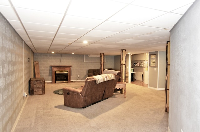 carpeted living room featuring a drop ceiling