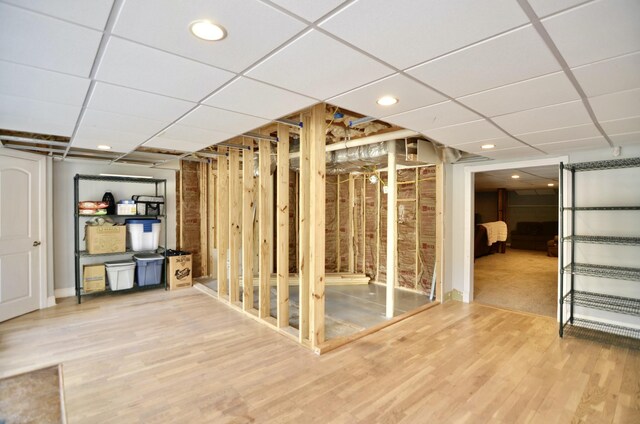 basement with hardwood / wood-style floors and a drop ceiling