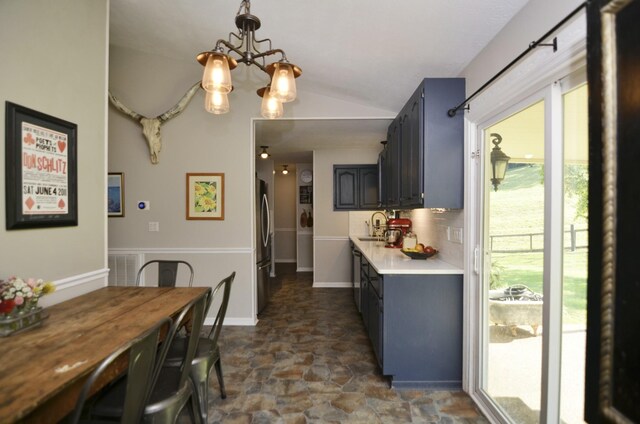 dining room with sink, a healthy amount of sunlight, lofted ceiling, and dark tile patterned floors