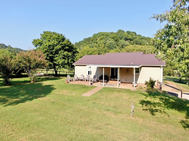 back of property with a patio and a yard