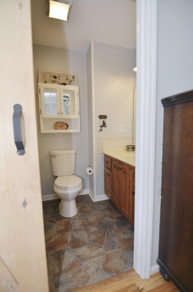 bathroom with toilet, vanity, and tile patterned flooring