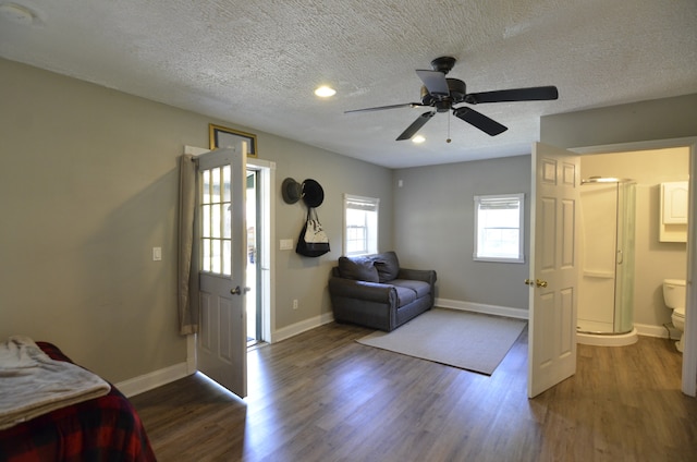 bedroom with a textured ceiling, dark hardwood / wood-style floors, and ceiling fan