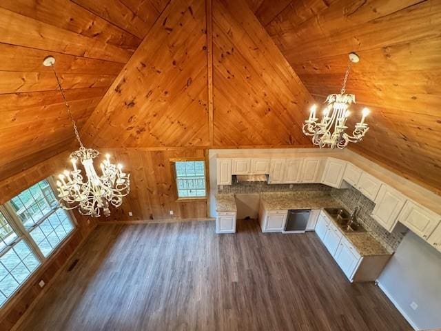 kitchen featuring hanging light fixtures, stainless steel dishwasher, white cabinets, and a notable chandelier