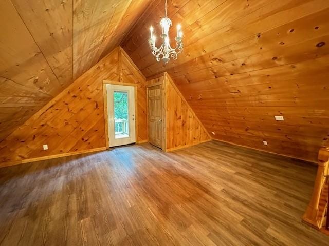 additional living space with vaulted ceiling, wooden walls, hardwood / wood-style flooring, a notable chandelier, and wooden ceiling