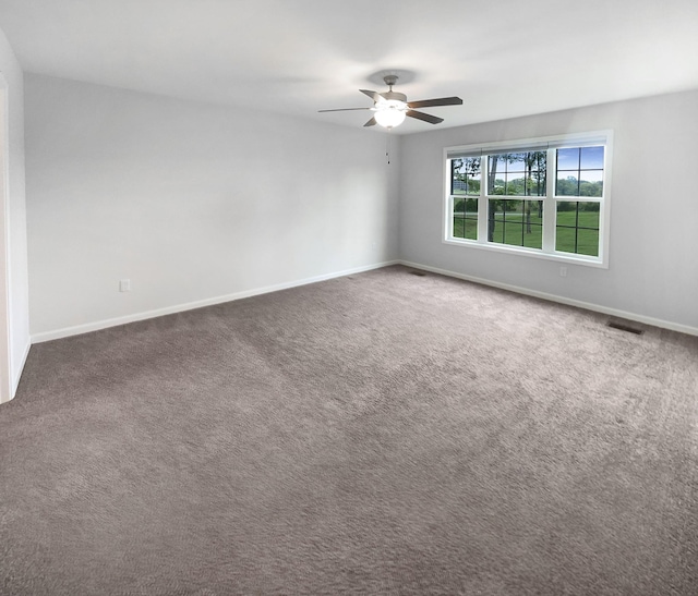 unfurnished room with dark carpet and ceiling fan