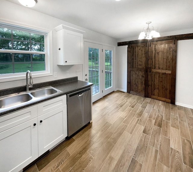 kitchen featuring a barn door, dishwasher, light hardwood / wood-style flooring, and white cabinets