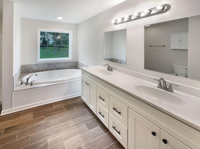 bathroom with vanity, toilet, and a tub