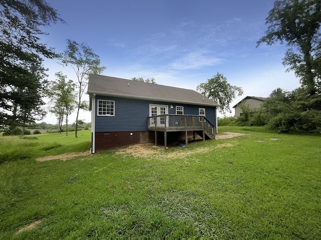 rear view of property with a wooden deck and a lawn