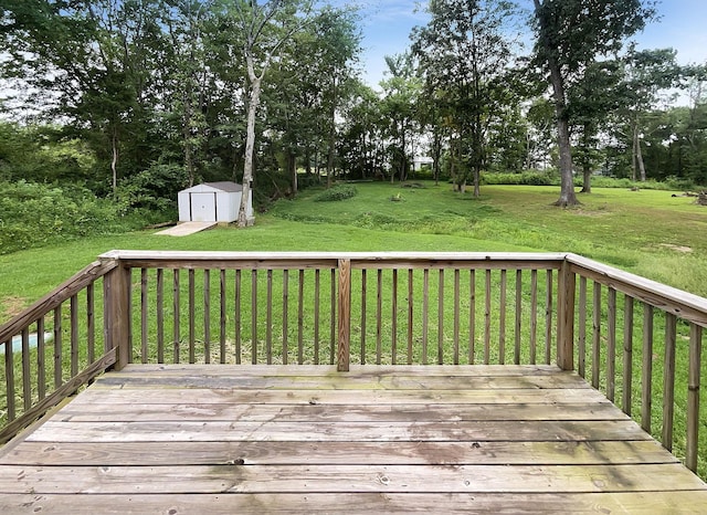 wooden terrace featuring a storage shed and a yard