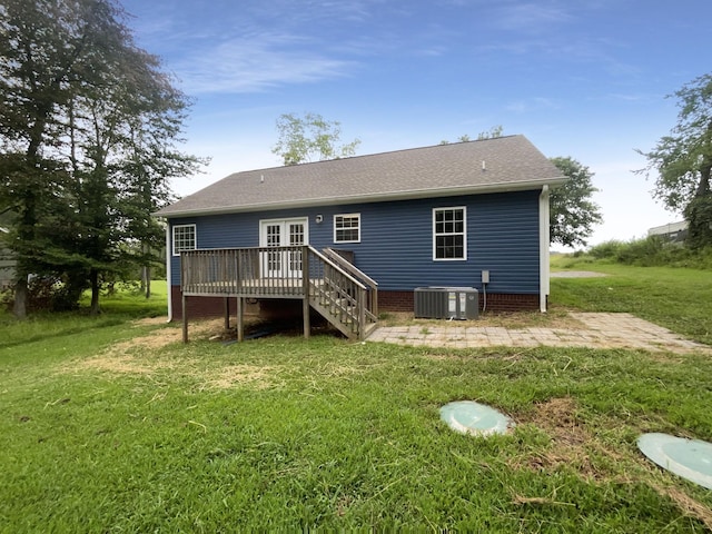 rear view of house featuring cooling unit, a lawn, french doors, and a deck