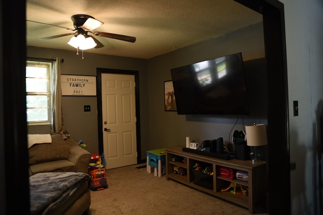 living room featuring a textured ceiling, ceiling fan, and carpet