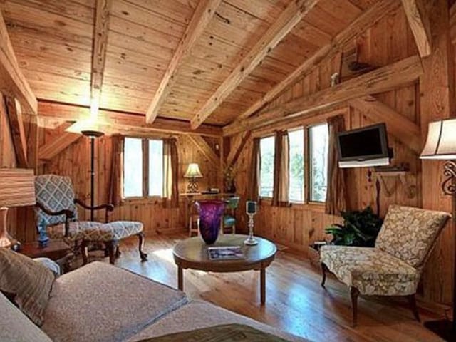 sitting room with wood ceiling, lofted ceiling with beams, hardwood / wood-style floors, and wood walls