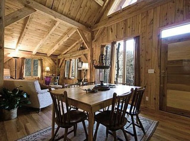 dining room featuring wood walls, plenty of natural light, and hardwood / wood-style floors