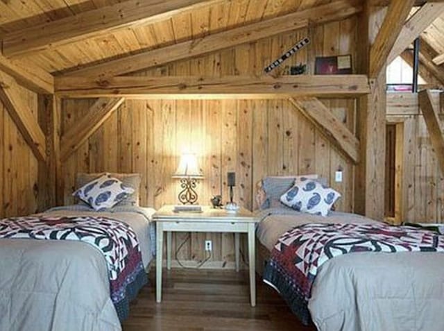 bedroom with wood walls, lofted ceiling with beams, hardwood / wood-style floors, and wood ceiling