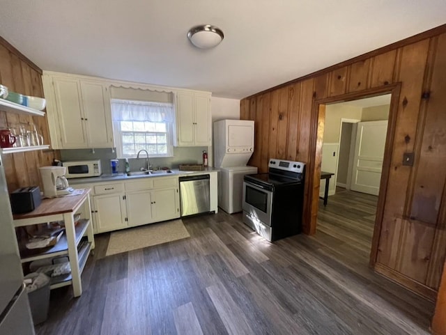 kitchen featuring stacked washer / dryer, sink, stainless steel appliances, and dark hardwood / wood-style floors