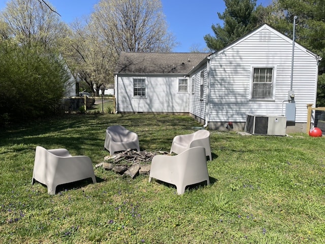 rear view of house with a lawn and cooling unit