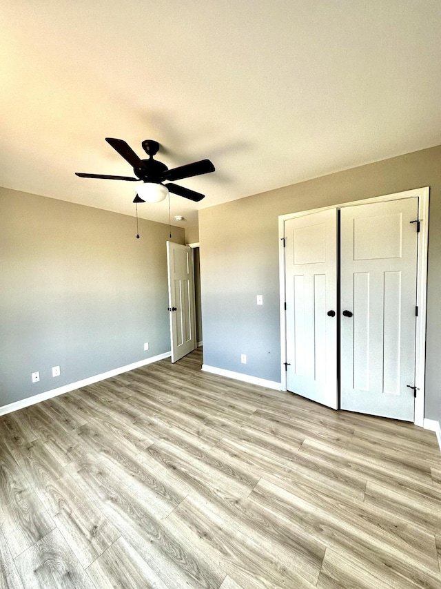 unfurnished bedroom featuring light hardwood / wood-style floors, a closet, and ceiling fan