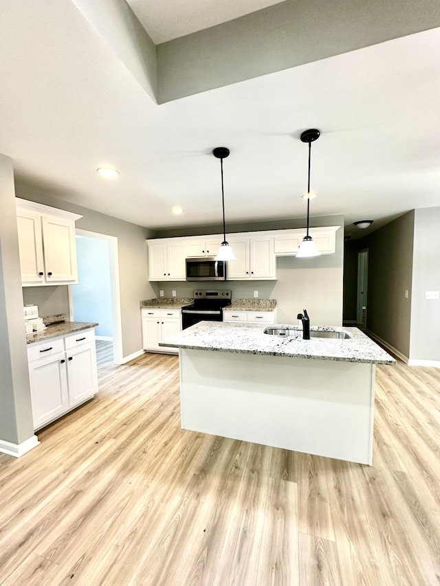 kitchen featuring sink, hanging light fixtures, electric range oven, white cabinets, and a center island with sink