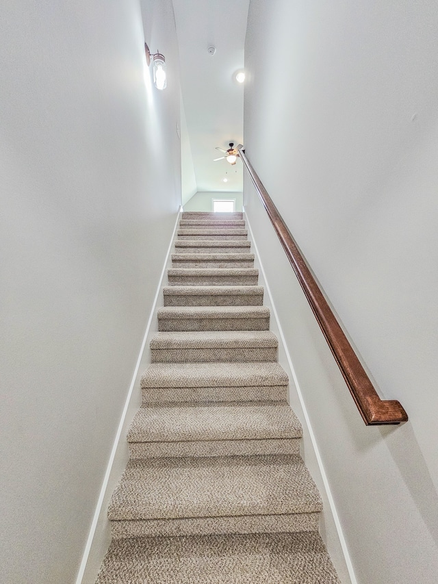 stairway featuring ceiling fan