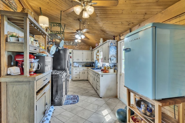 kitchen featuring light tile patterned floors, refrigerator, white cabinets, ceiling fan, and sink