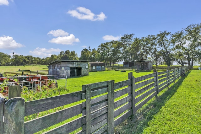 view of yard with an outdoor structure and a rural view