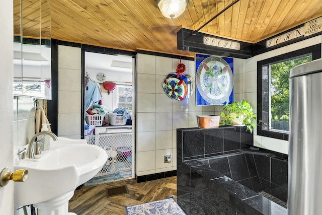 bathroom featuring tile walls, parquet floors, sink, and wooden ceiling