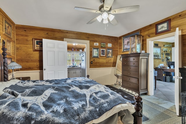 bedroom with tile patterned floors, wood walls, and ceiling fan