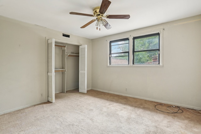 unfurnished bedroom featuring light carpet, a closet, and ceiling fan