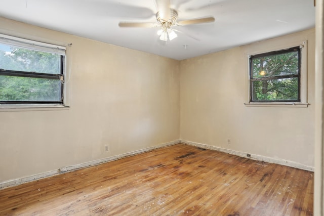 spare room featuring ceiling fan, wood-type flooring, and plenty of natural light