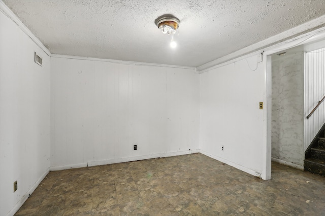 basement with tile patterned flooring and a textured ceiling