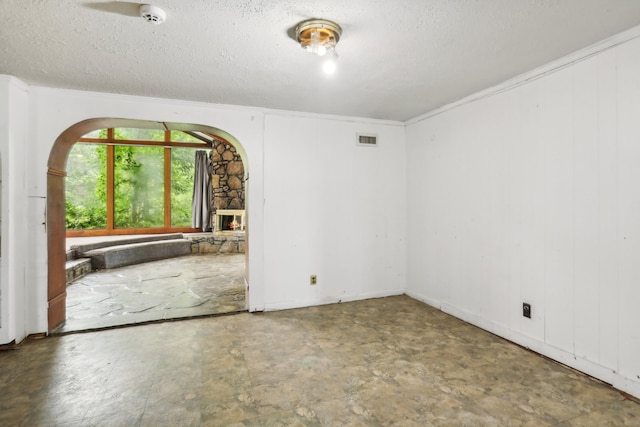 tiled spare room featuring a fireplace and a textured ceiling