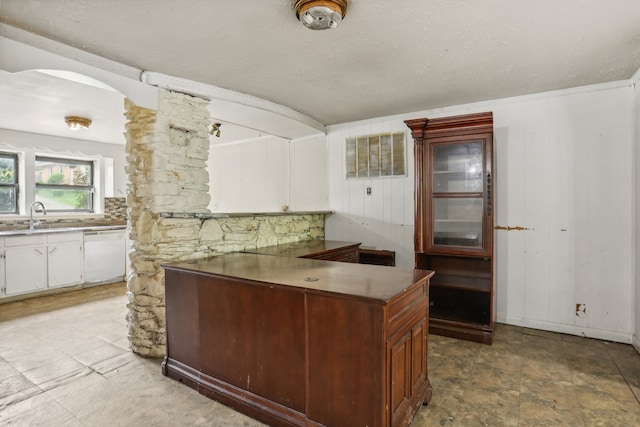 kitchen with white cabinetry, sink, white dishwasher, light tile patterned floors, and backsplash