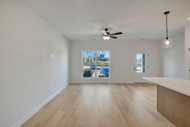 unfurnished living room with plenty of natural light, ceiling fan, and light wood-type flooring