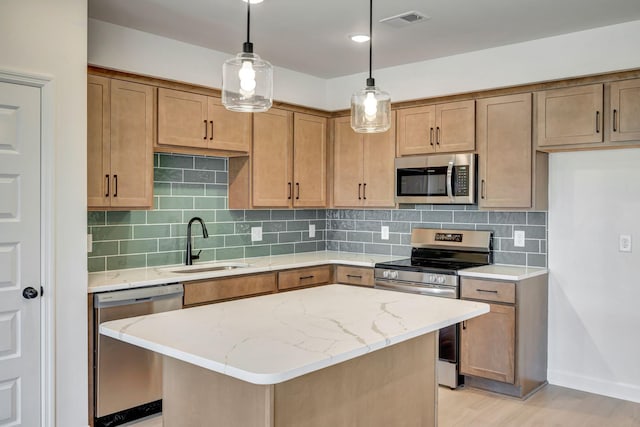 kitchen featuring pendant lighting, sink, stainless steel appliances, and a center island