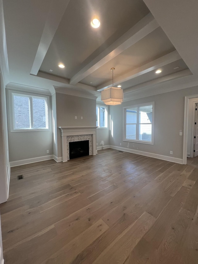 unfurnished living room featuring wood-type flooring and beam ceiling