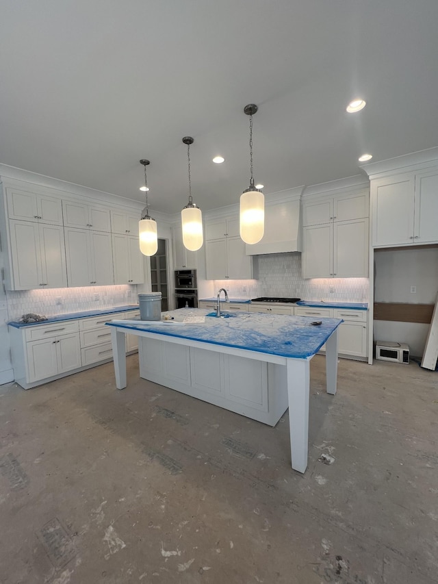 kitchen featuring decorative backsplash, white cabinetry, premium range hood, and a kitchen island with sink