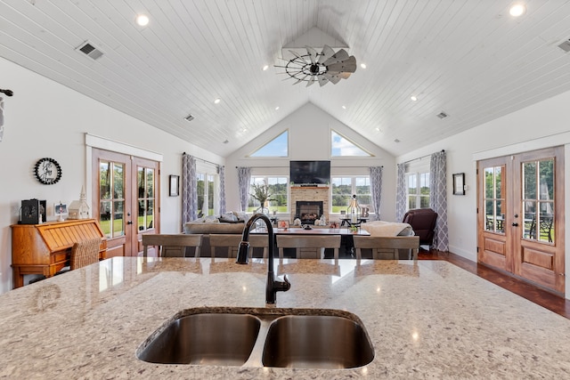 kitchen with sink, french doors, wooden ceiling, a fireplace, and hardwood / wood-style flooring