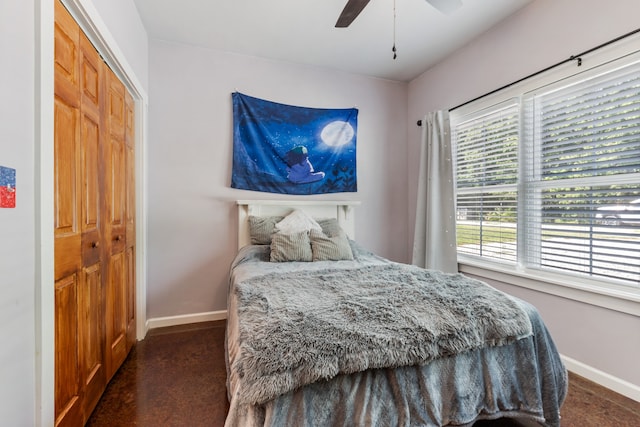 bedroom with dark colored carpet, a closet, and ceiling fan