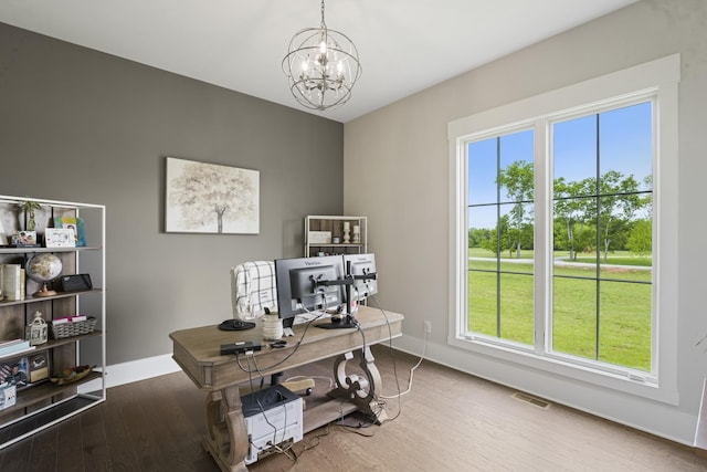 home office featuring an inviting chandelier and hardwood / wood-style floors