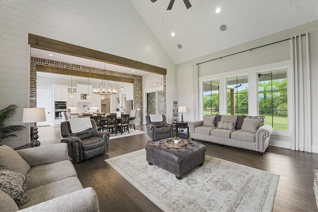 living room featuring dark hardwood / wood-style floors, ceiling fan with notable chandelier, and high vaulted ceiling