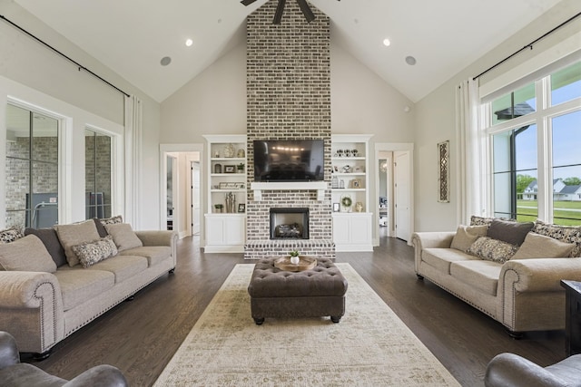 living room with dark wood-type flooring, a fireplace, and high vaulted ceiling