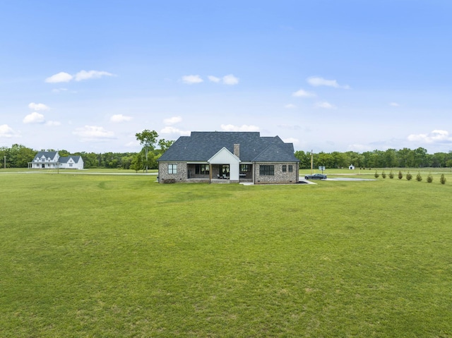 view of front of home featuring a front lawn and a rural view